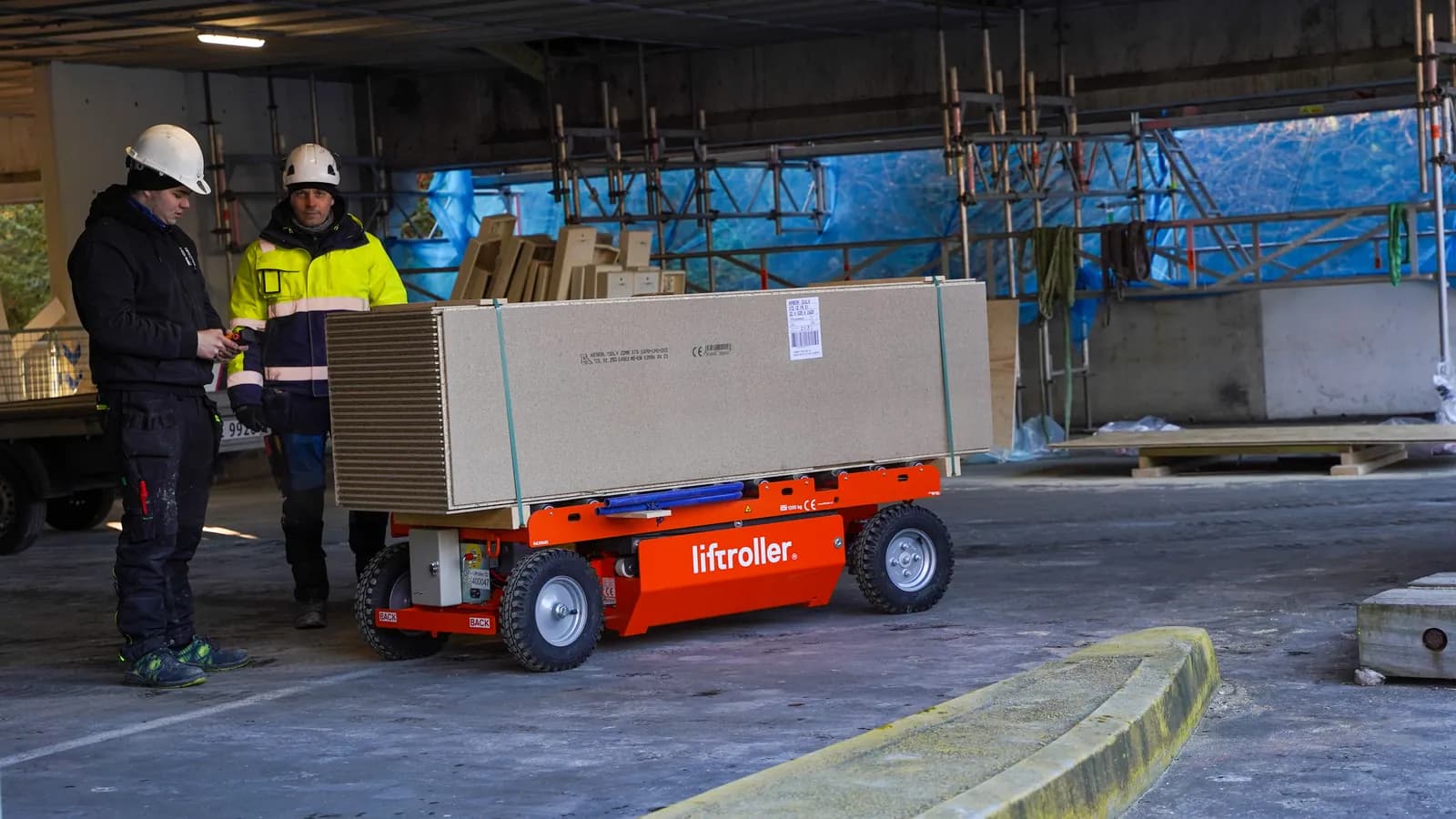 Worker operating a Liftroller E Wagon with the handheld remote control inside a building